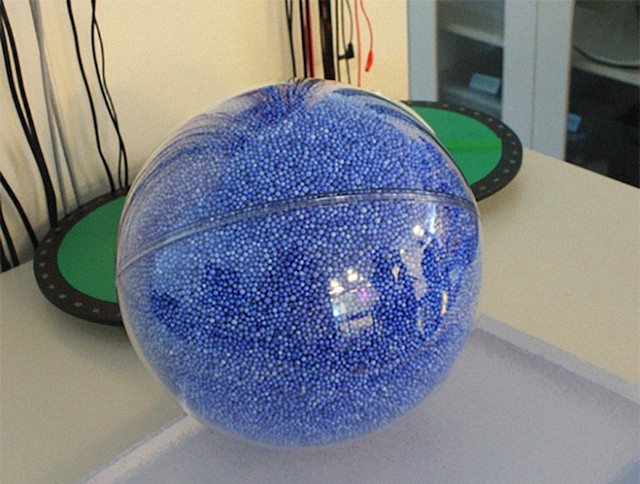 Plava zrnca predstavljaju našu planetu, a prozirna lopta Sunce