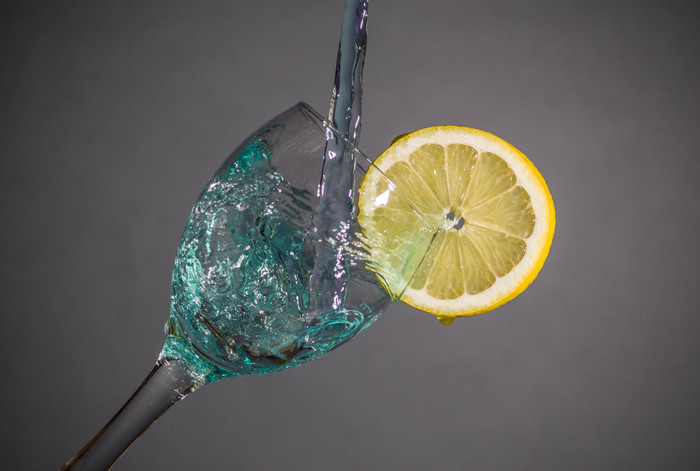 Water drops in wine glass with lemon 